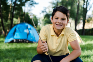 boy camping with marshmellows